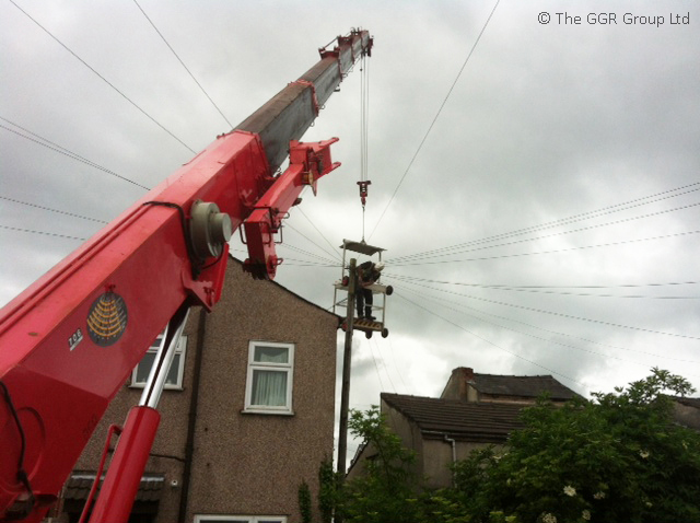Telecoms repair working using mini crane and man basket