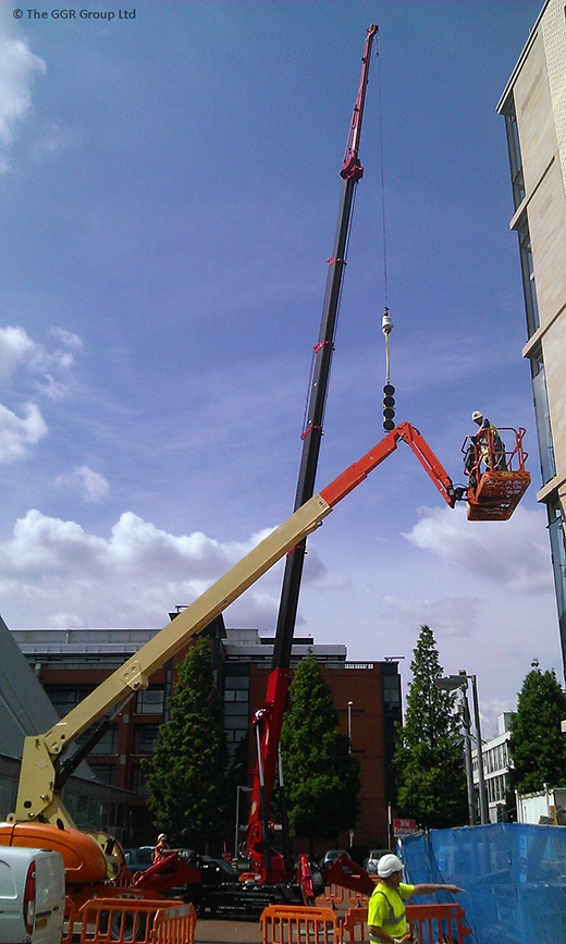 UNIC URW-1006 mini crane installing glazing at Manchester apartment block