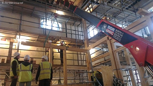 UNIC URW-376 lifting wooden beams at indoor theatre