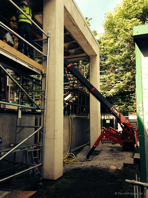 UNIC mini spider crane working in a restricted access area