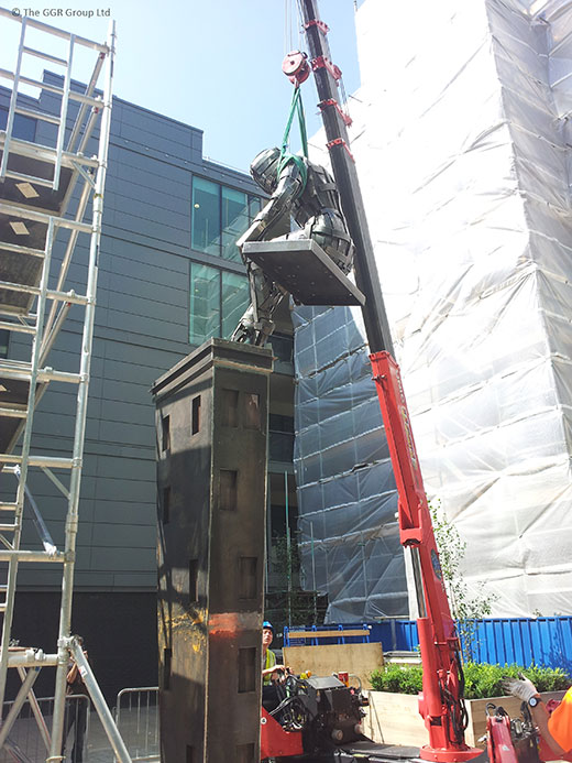 UNIC URW-376 crane lifts figure on top of statue