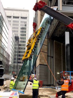 GGR Group's UNIC URW-1006 mini spider crane lifting a Hydraulica 2100 curved glass vacuum lifter.