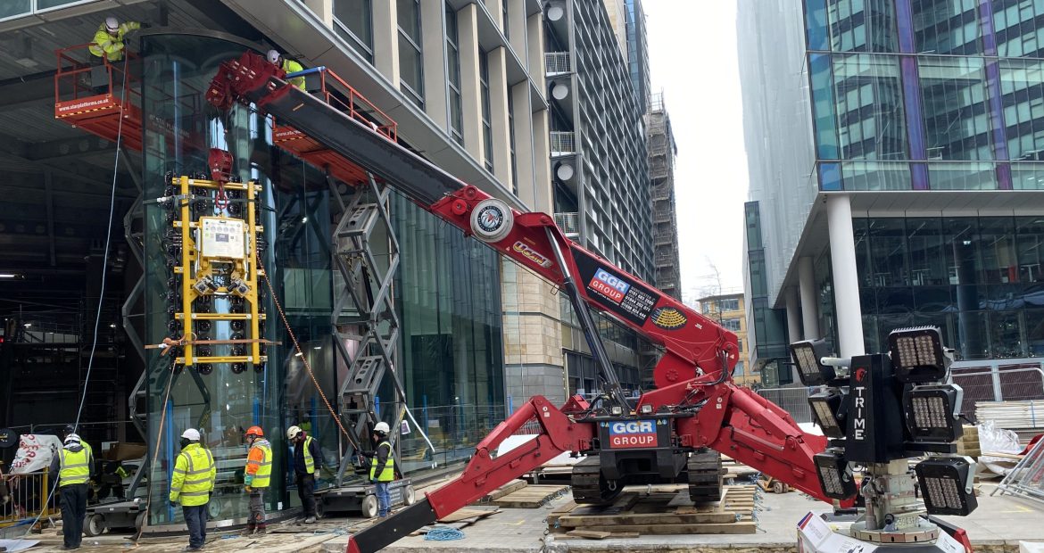 GGR Group's UNIC URW-1006 mini spider crane lifting a Hydraulica 2100 curved vacuum lifter.