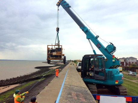 GGR Group's MCC500D Mini Crawler Crane lifting an excavator over a sea wall on Canvey Island.