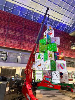 UNIC URW-546 Mini Spider Crane lifting sections of a Christmas tree inside a shopping centre.