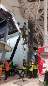 TMC 25 Articulated Crawler Crane and a Hydraulica 1200 Glass Vacuum Lifter installing glazing for a shopping centre. Sustainable construction practices.
