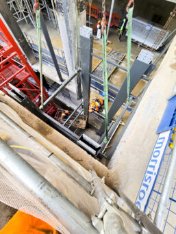 The UNIC URW-706 Mini Spider Crane lifting components of a passenger lift.